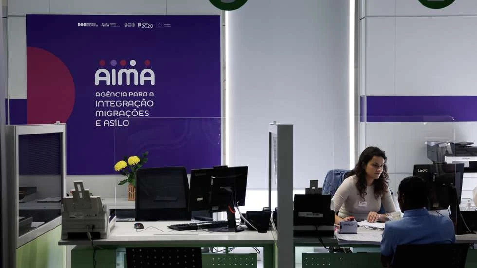Співробітниця AIMA консультує відвідувача за стійкою відділення — запис на прийом в AIMA